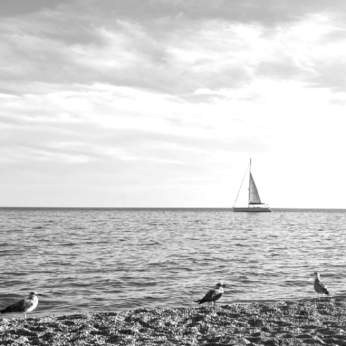 Ein kleines Segelboot an der italienischen Küste, das auf Kurs geht